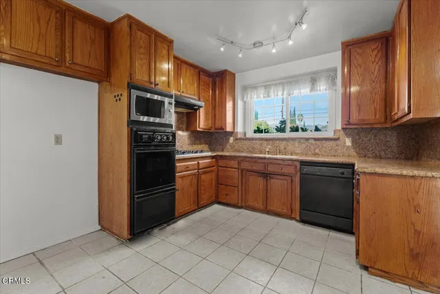 a kitchen with stainless steel appliances granite countertop a refrigerator and a stove top oven