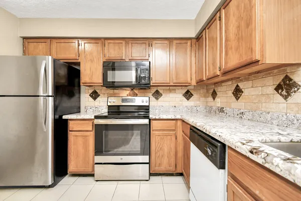 a kitchen with stainless steel appliances granite countertop a refrigerator stove and sink