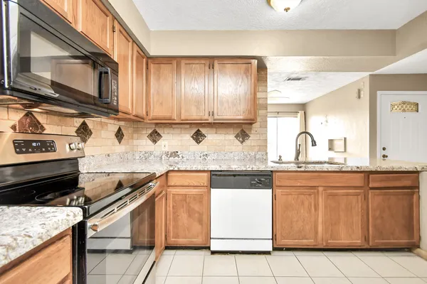 a kitchen with stainless steel appliances granite countertop a sink and a stove
