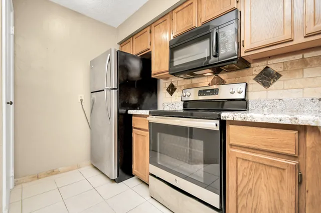 a kitchen with stainless steel appliances granite countertop a refrigerator stove and microwave