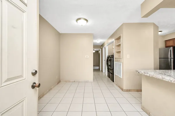 a view of a hallway to closet and kitchen