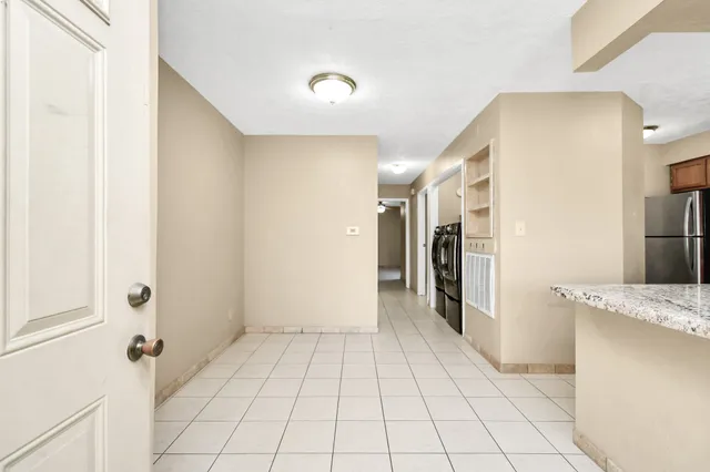 a view of a hallway to closet and kitchen
