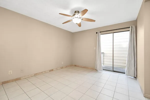 an empty room with windows and fan