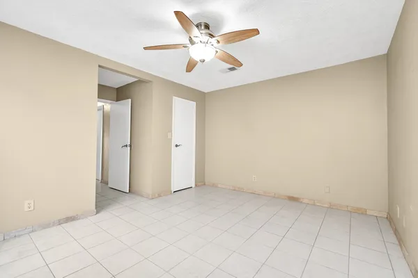 an empty room with chandelier fan