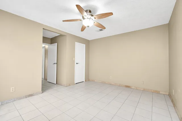 an empty room with chandelier fan
