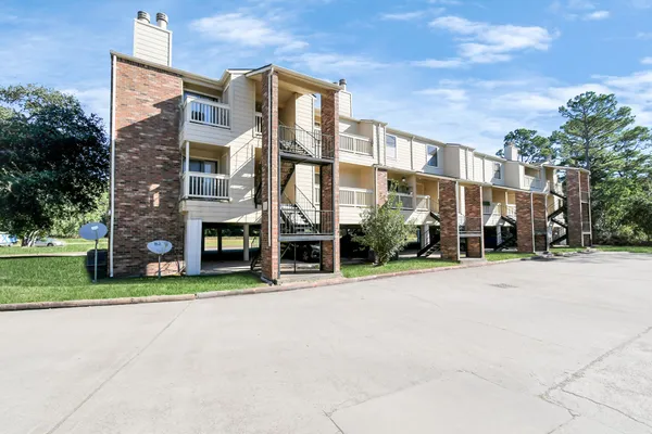 a front view of a building with a garden and plants