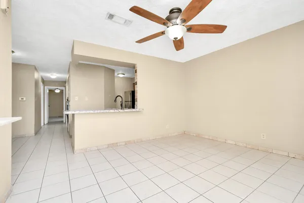 an empty room with a ceiling fan and a rug