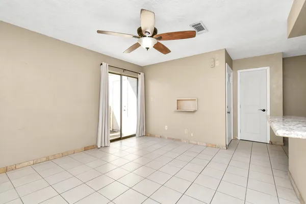 an empty room with fan and windows