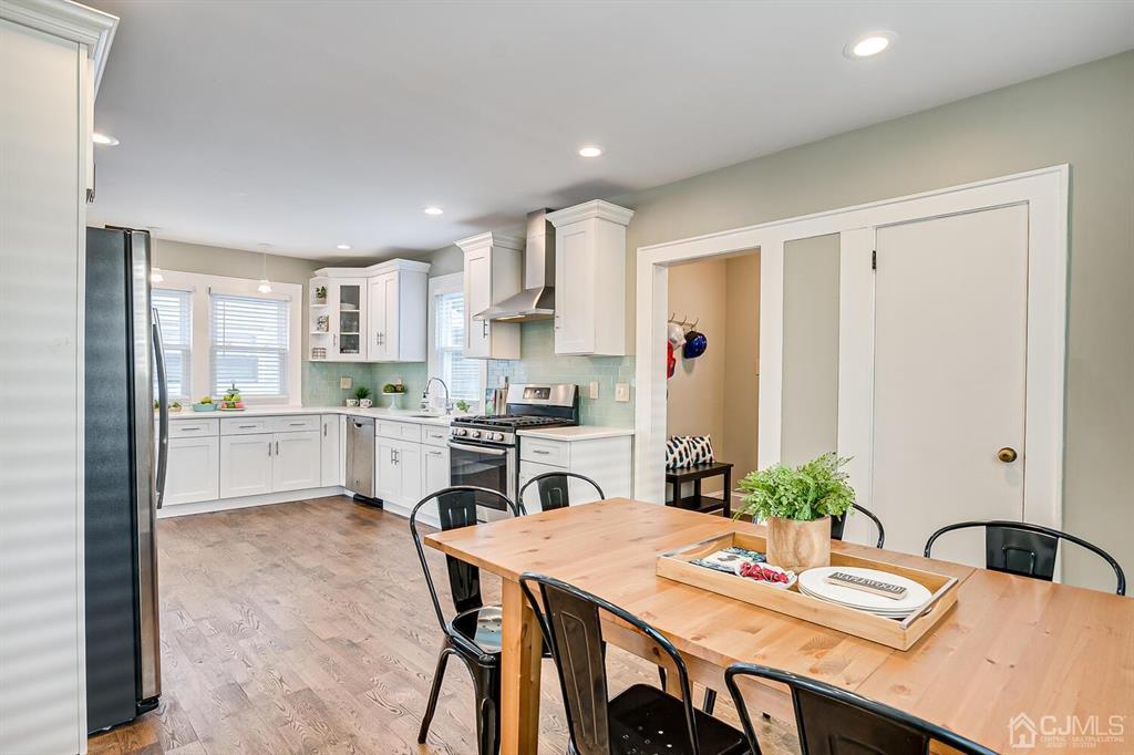 79 Van Ness Terrace Maplewood, NJ 07040 - Photo 19 of 40 a open dining room with stainless steel appliances kitchen island granite countertop a dining table chairs and a refrigerator