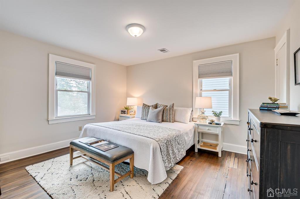 79 Van Ness Terrace Maplewood, NJ 07040 - Photo 24 of 40 a bedroom with a bed and a table in it with wooden floor