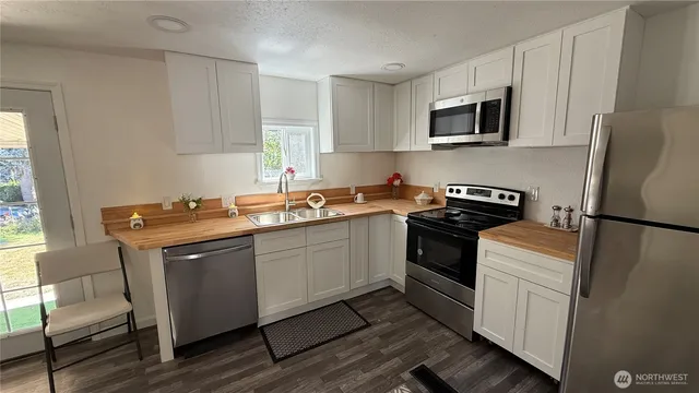 a kitchen with stainless steel appliances granite countertop a sink stove microwave and refrigerator