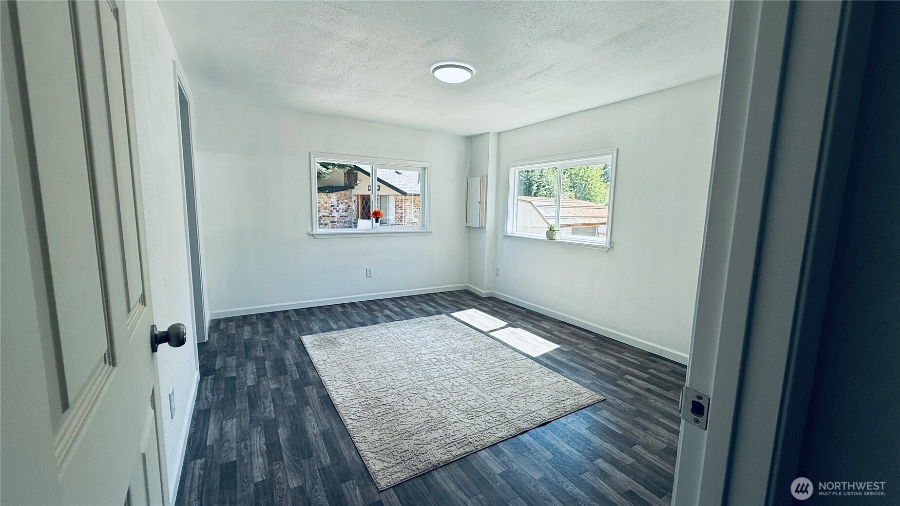 11517 155th Avenue Southeast Renton, WA 98059 - Photo 4 of 17 an empty room with wooden floor and windows