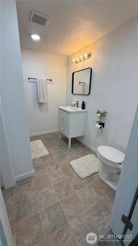 a bathroom with a toilet sink and mirror