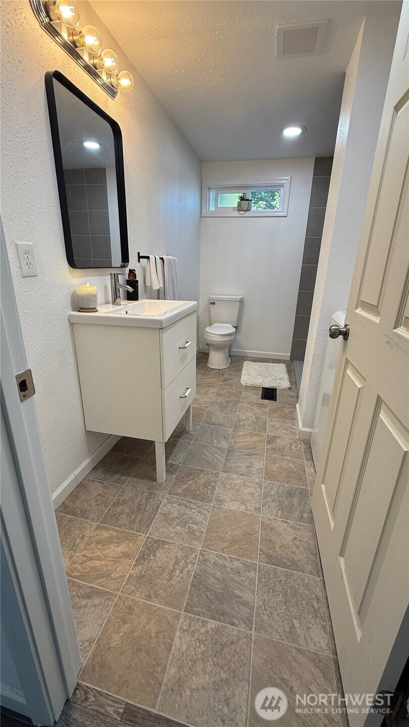 11517 155th Avenue Southeast Renton, WA 98059 - Photo 8 of 17 a bathroom with a sink a toilet and mirror