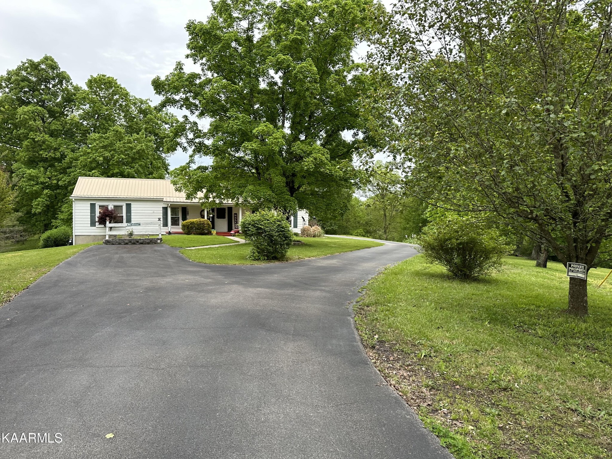 a front view of a house with a yard and trees