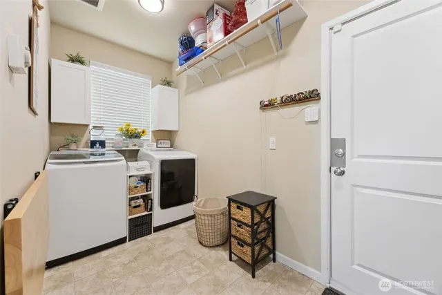 a utility room with fridge dryer and washer