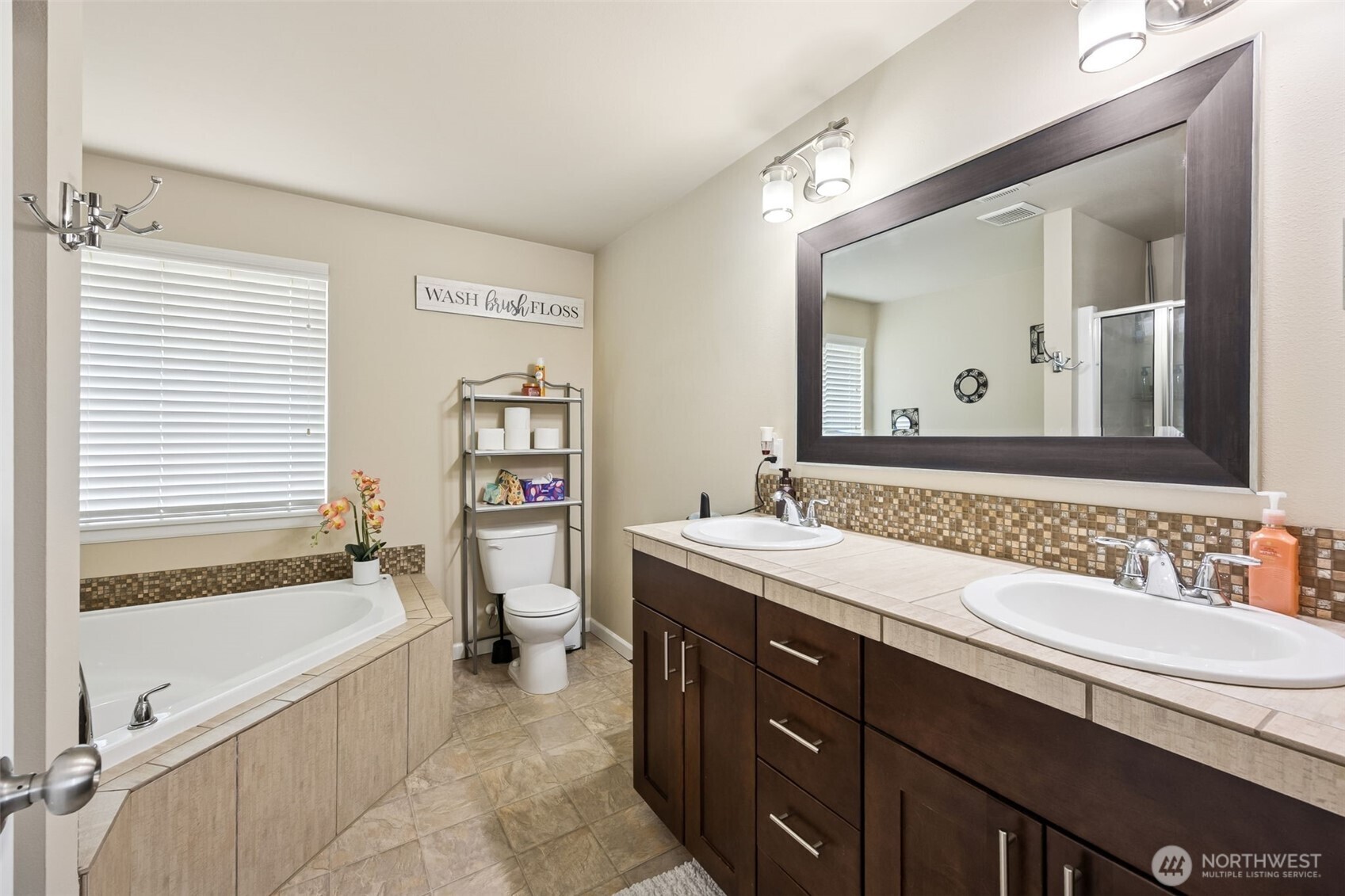 103 Balmer Street Southwest Orting, WA 98360 - Photo 18 of 30 a bathroom with a tub double sink window and mirror