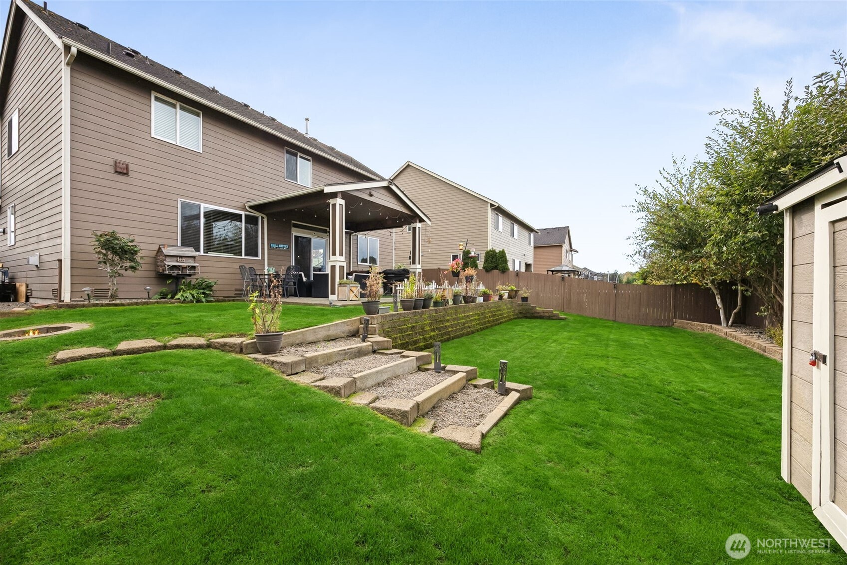 103 Balmer Street Southwest Orting, WA 98360 - Photo 29 of 30 a backyard of a house with table and chairs