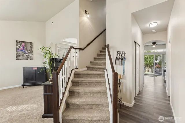 a view of staircase with lots of frames and frames on wall and wooden floor
