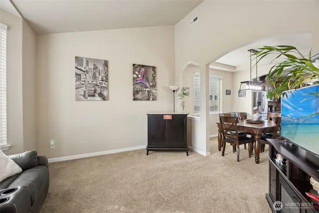 a living room with furniture a dining table and paintings on the wall