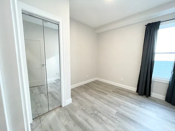 an empty room with wooden floor and a window