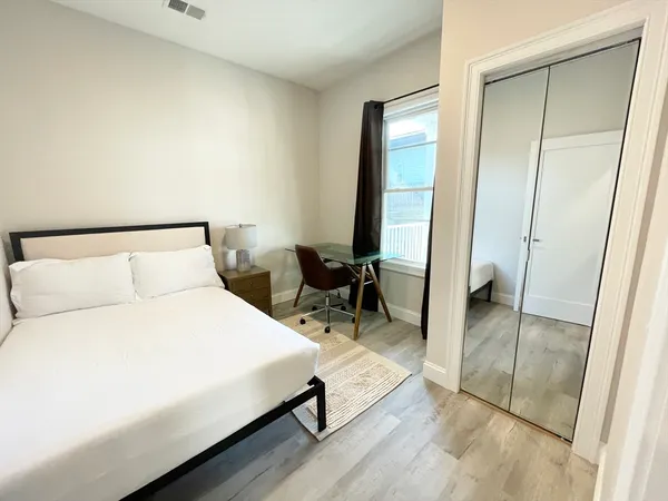 a bedroom with a bed and a mirror