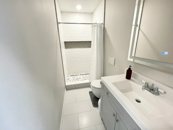 a bathroom with a sink a toilet and a mirror