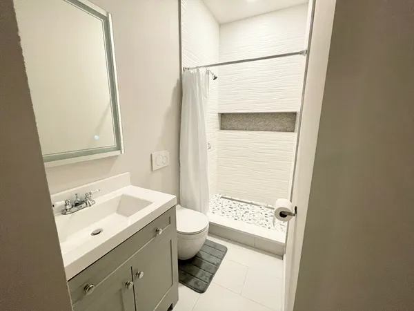 a bathroom with a sink toilet and shower