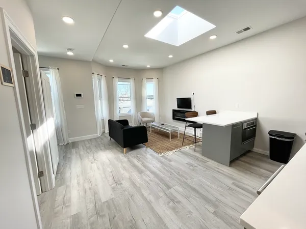 a kitchen with stainless steel appliances kitchen island granite countertop a stove a sink and a refrigerator with wooden floor