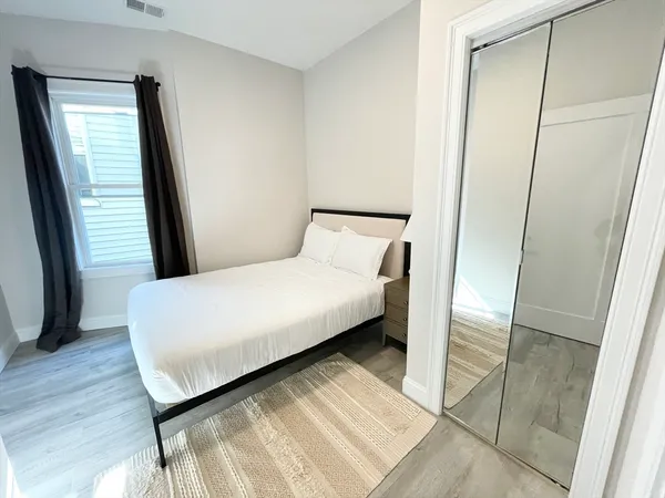 a large bed sitting in a bedroom next to a window