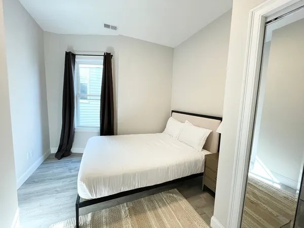 a bedroom with a bed and wooden floor