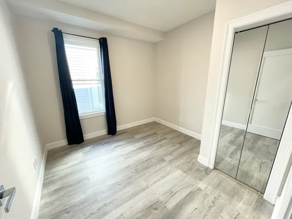 an empty room with wooden floor and entrance
