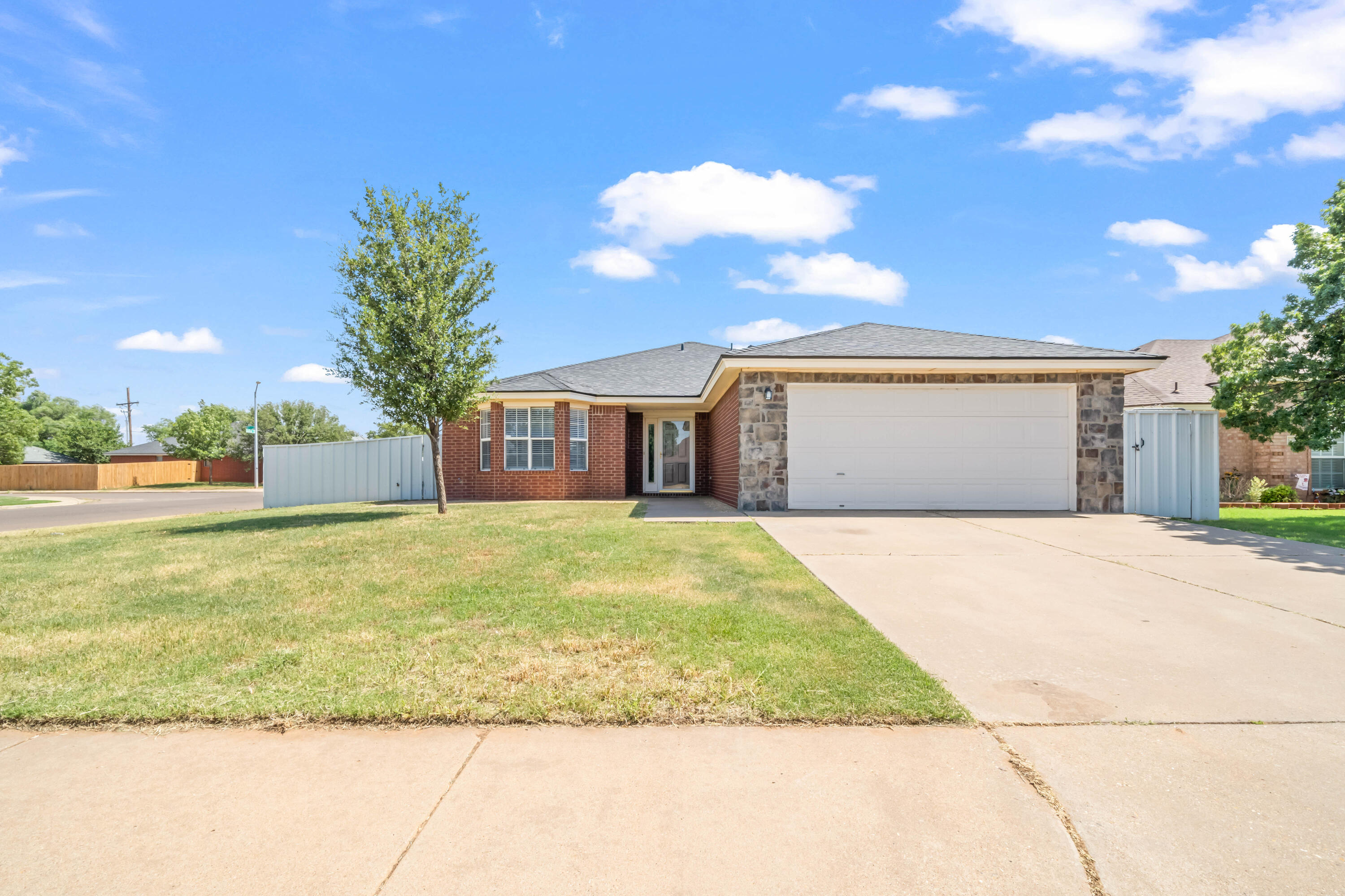 6201 5th Street Lubbock, TX 79416 - Photo 1 of 25 a front view of a house with a garden and trees