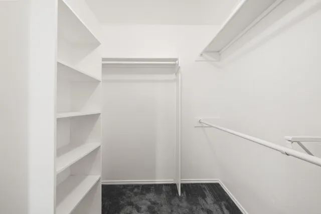 a view of walk in closet with empty racks