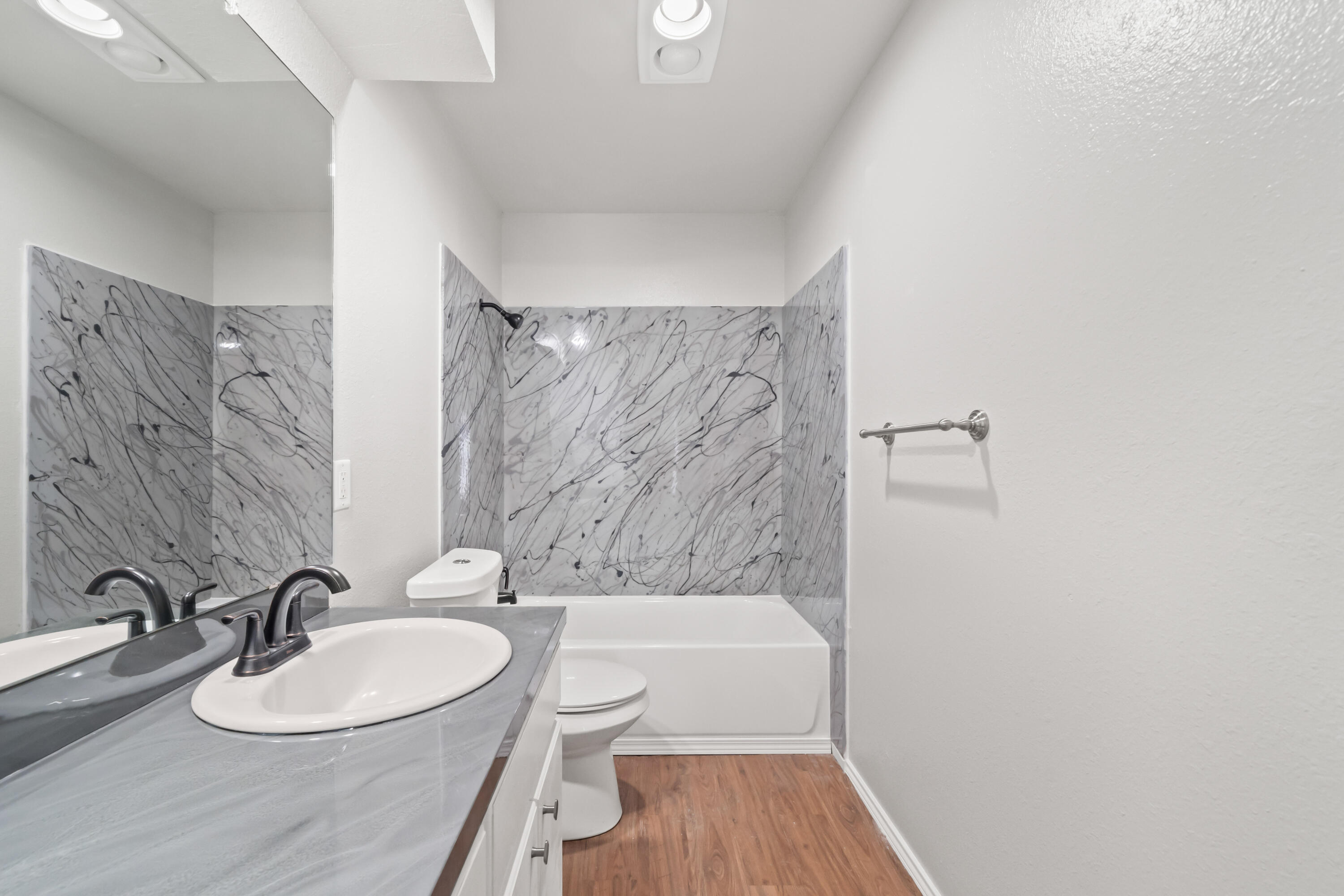 6201 5th Street Lubbock, TX 79416 - Photo 16 of 25 a bathroom with a sink toilet a mirror and shower