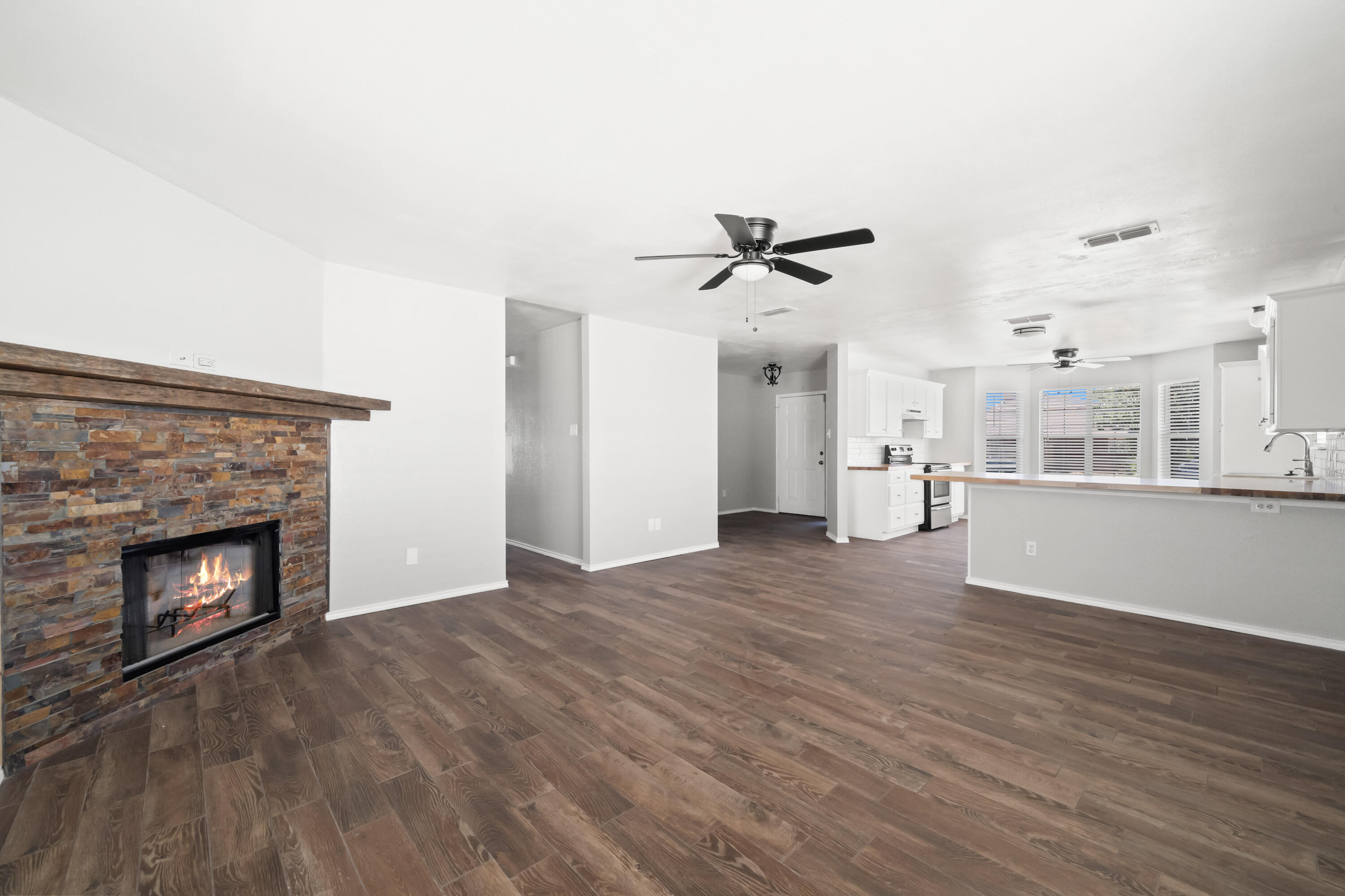 6201 5th Street Lubbock, TX 79416 - Photo 2 of 25 a view of empty room with wooden floor and fireplace