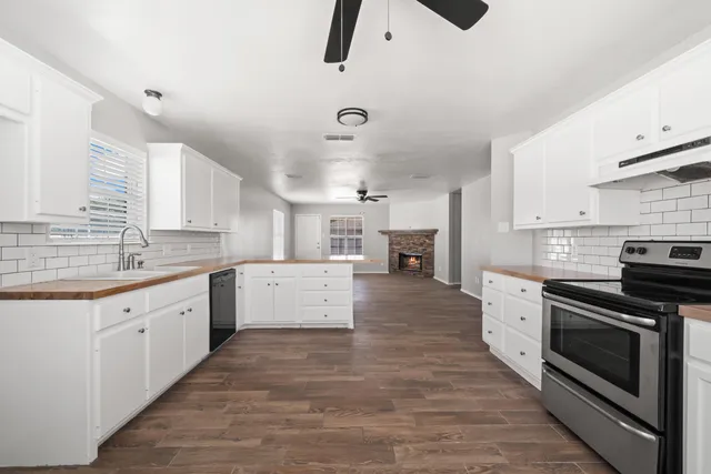 a large kitchen with stainless steel appliances granite countertop a stove and a sink