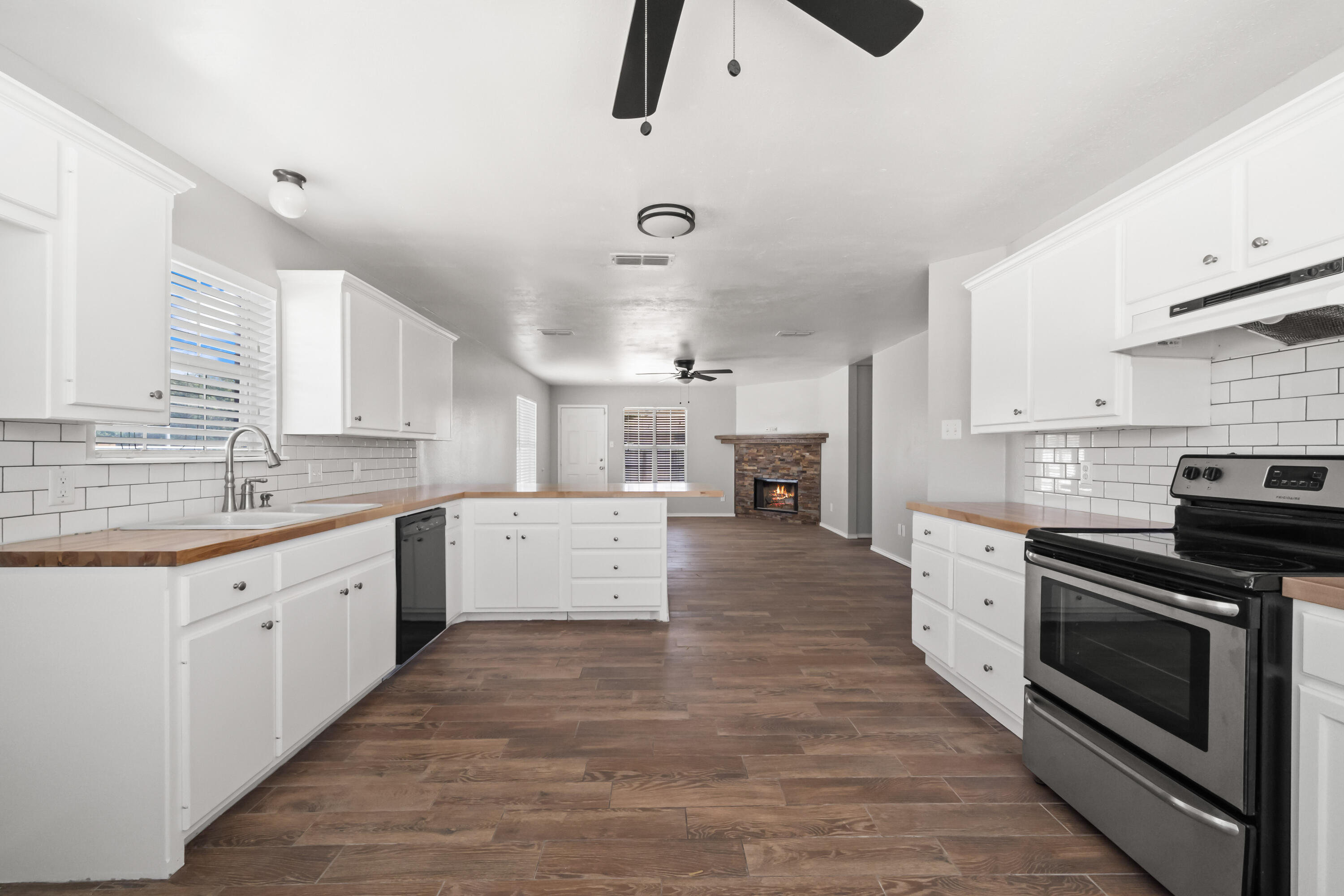 6201 5th Street Lubbock, TX 79416 - Photo 5 of 25 a large kitchen with stainless steel appliances granite countertop a stove and a sink