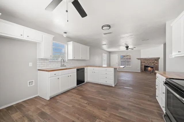 a large kitchen with stainless steel appliances a large counter top a stove a sink dishwasher and a refrigerator