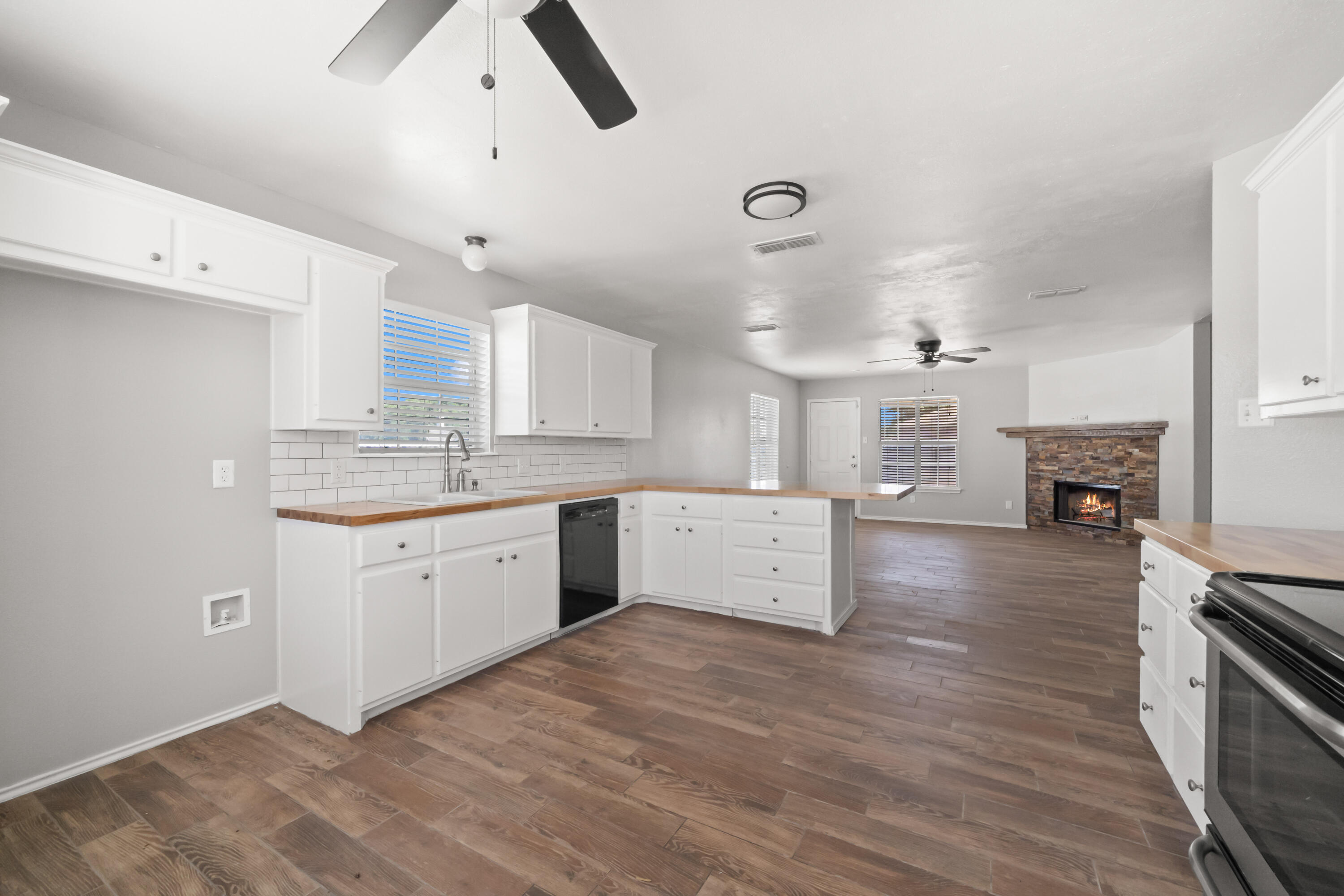 6201 5th Street Lubbock, TX 79416 - Photo 6 of 25 a large kitchen with stainless steel appliances a large counter top a stove a sink dishwasher and a refrigerator