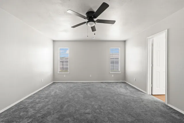 a view of an empty room with a ceiling fan