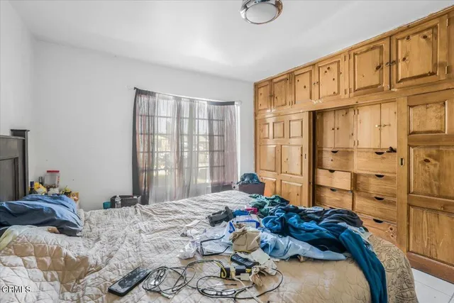 a bedroom with a bed dresser and a window