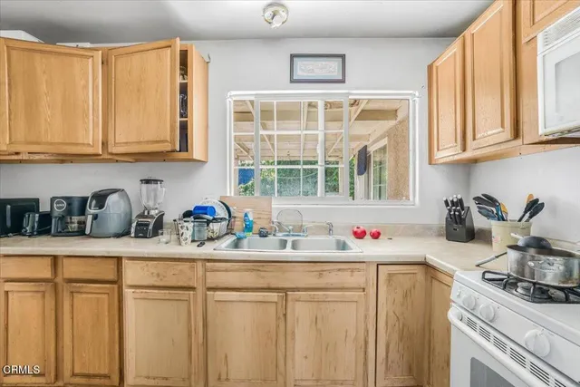 a kitchen with stainless steel appliances granite countertop a sink a stove and cabinets