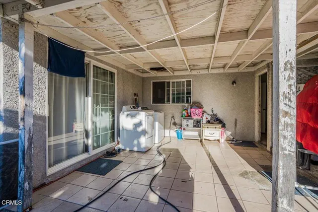 a view of a patio with table and chairs potted plants and a palm tree