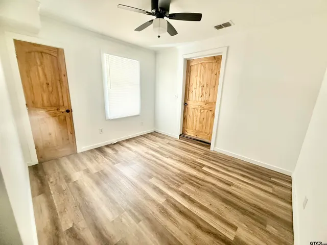 a view of a livingroom with wooden floor and a ceiling fan