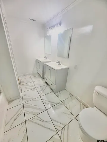 a bathroom with a sink mirror vanity and toilet