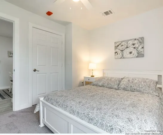 a bedroom with a bed and painting on the wall