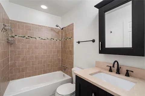 a bathroom with a granite countertop sink toilet and shower