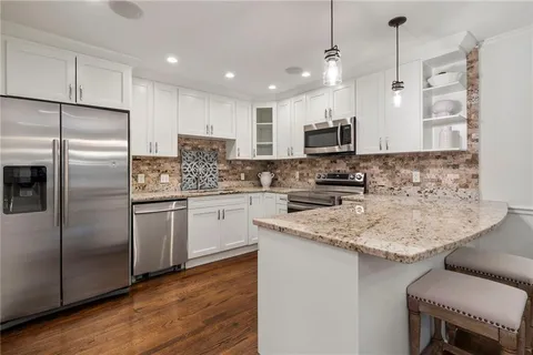 a kitchen with stainless steel appliances granite countertop a sink refrigerator and microwave