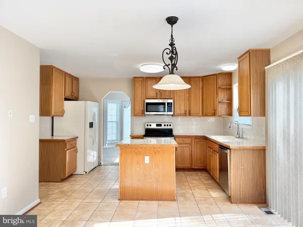 a kitchen with stainless steel appliances granite countertop a sink a stove and refrigerator
